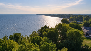 Aerial view of the Lake Erie shoreline in Kingsville, with mature trees and homes beside the water.